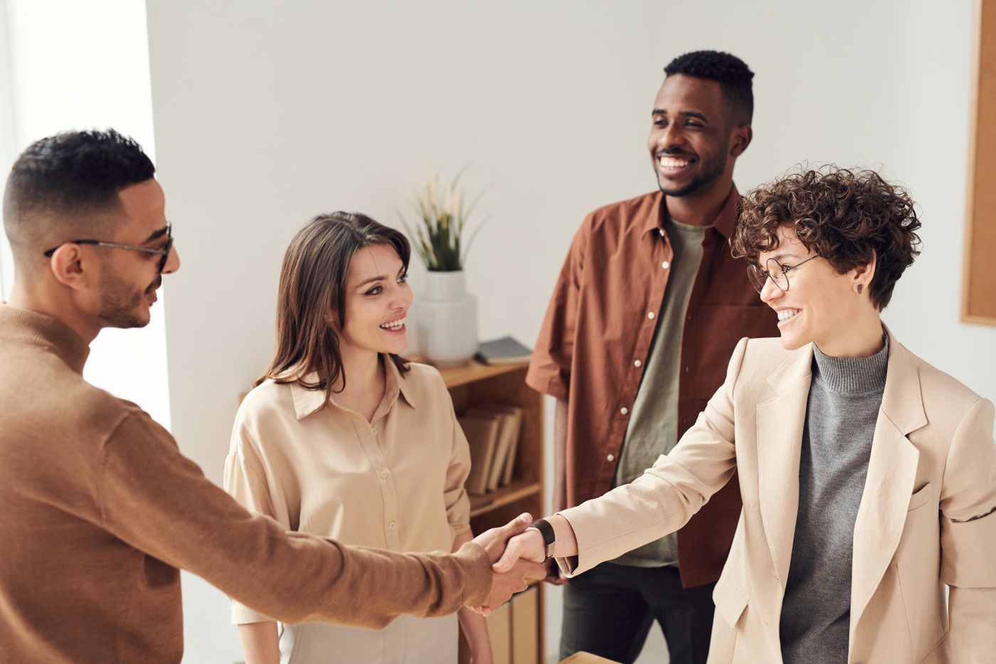 A smiling team greeting a visitor in an office