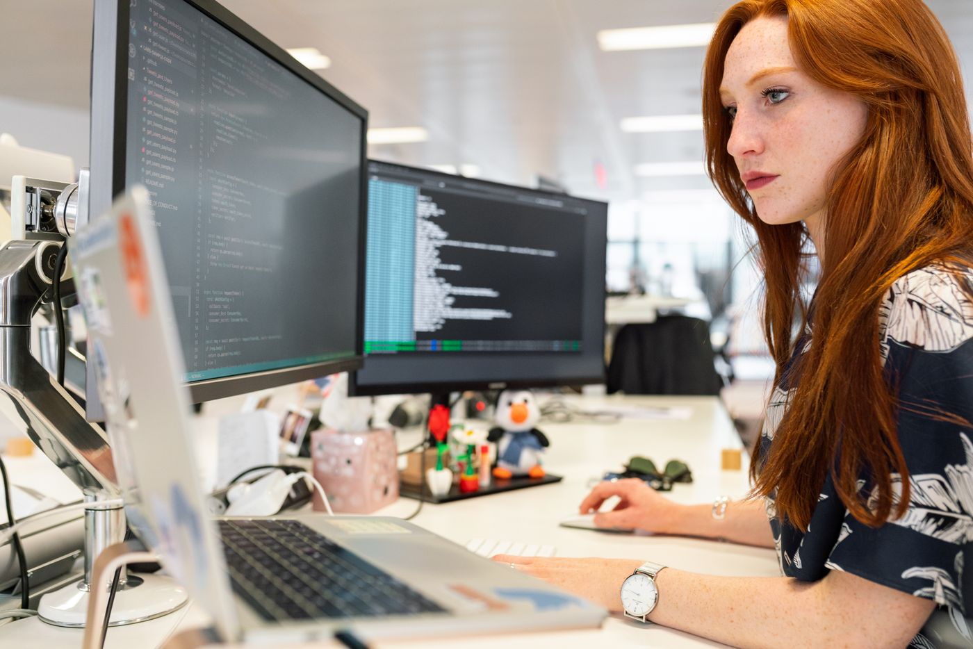 Engineer reviewing application code across multiple screens